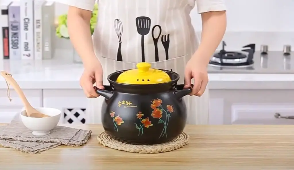 stylish clay made ceramic cookware in a kitchen held by chef